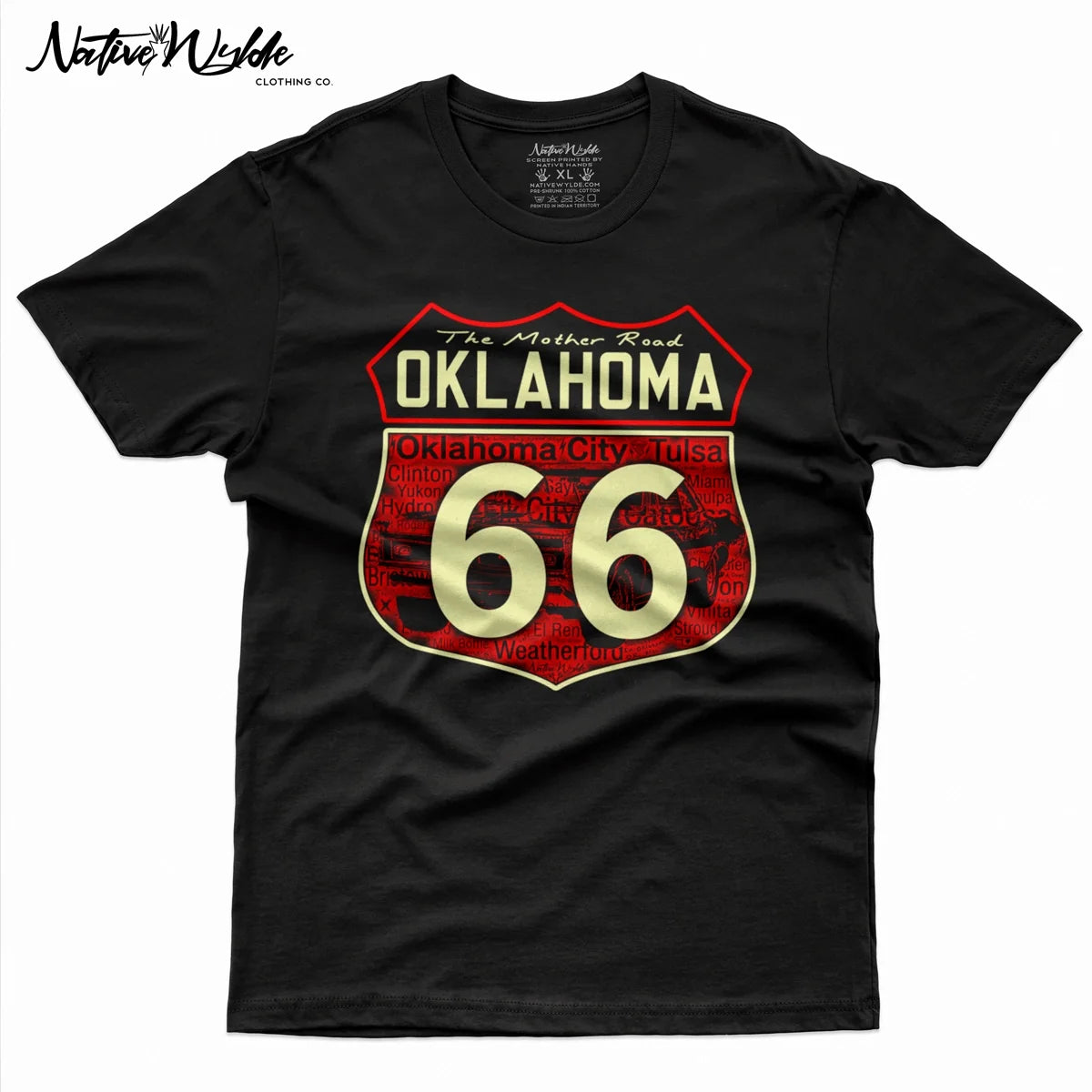 A black  t-shirt featuring a large graphic of the Oklahoma Route 66 shield on the front. The graphic has a red background with a pattern of the cities Route 66 travels through and bone colored lettering  that reads 'The Mother Road OKLAHOMA' 