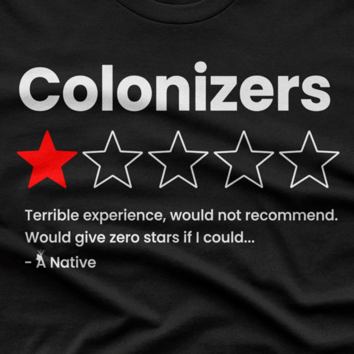 A close-up of a black t-shirt featuring a humorous graphic. The graphic displays the word 'Colonizers' in bold white letters above a one-star review out of five, with the first star filled in red.