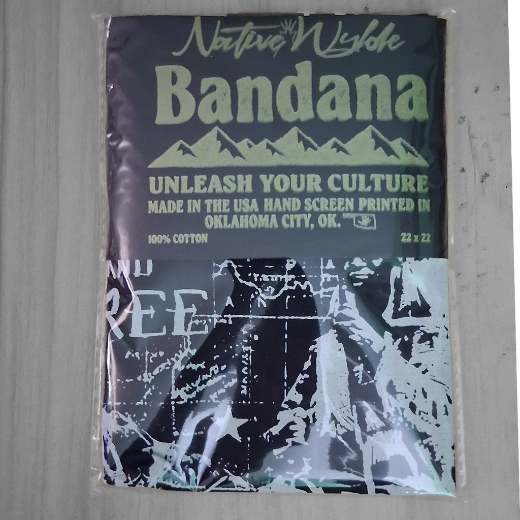 A packaged cotton bandana with a dark navy top section featuring light green text and mountain graphics, plus a black-and-white graphic print on the lower half. The package reads 'Native Wylde  Bandana' and 'Unleash Your Culture.