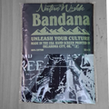 A packaged cotton bandana with a dark navy top section featuring light green text and mountain graphics, plus a black-and-white graphic print on the lower half. The package reads 'Native Wylde  Bandana' and 'Unleash Your Culture.