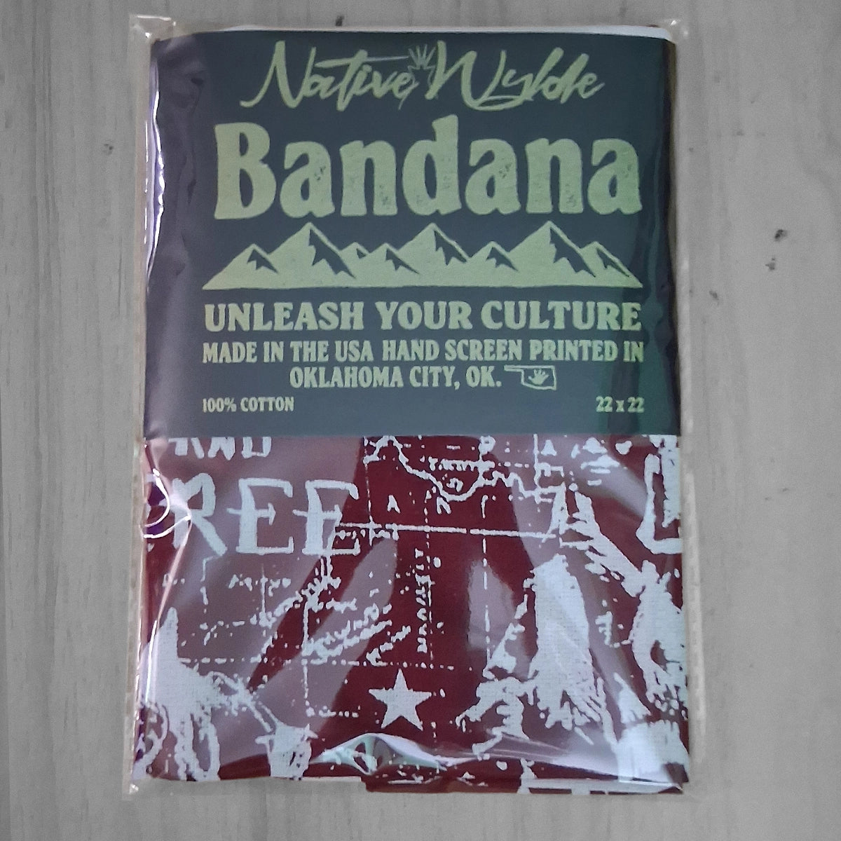 A packaged Native Wiskle bandana with a header card and a red-and-white printed fabric below, photographed on a light wood surface.