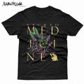 A black T-shirtfeaturing a large graphic print with the words 'SACRED MEDICINE' in bone lettering, layered over botanical illustrations in green and purple.