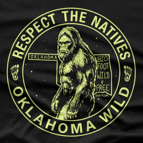 A black short-sleeve crewneck t-shirt featuring a circular graphic print of Bigfoot in the center with the text 'RESPECT THE NATIVES' and 'OKLAHOMA WILD' in bone color around the border. 
