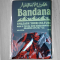 A packaged Native Waffle Bandana featuring a dark blue and red graphic print of a Native American figure, sealed in clear plastic on a light gray background.