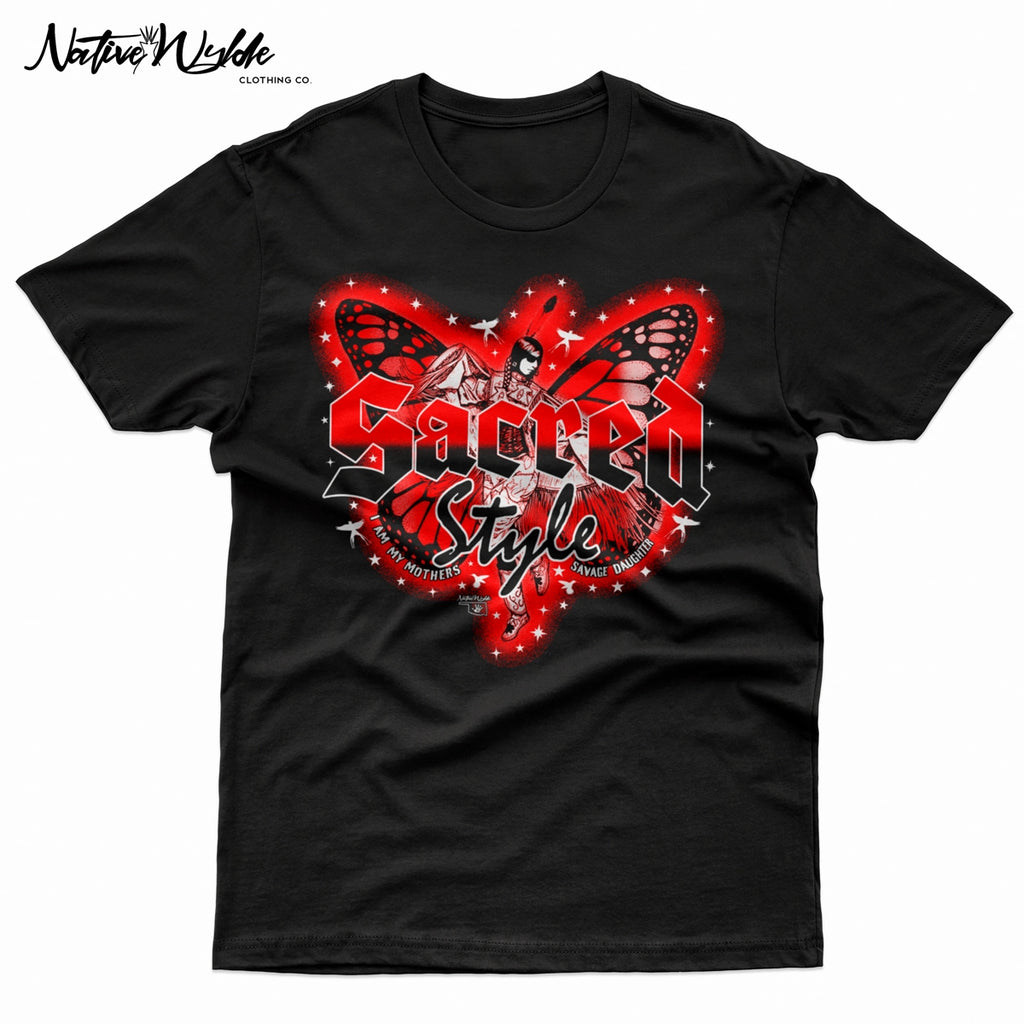 A black graphic t-shirt featuring a red and black butterfly design with the text 'Sacred Style' and 'I AM MY MOTHERS SAVAGE DAUGHTER'. Fancy shawl Native American dancer in the middle of the wings.